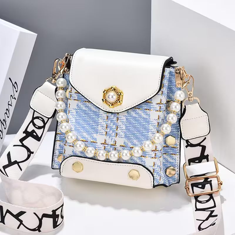 Designer handbag with pearl embellishments on a white background