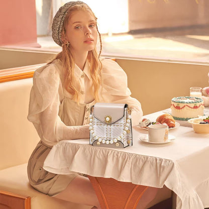 Woman sitting at a table with a handbag and a cake in a softly lit room.