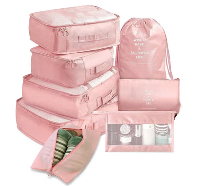 Set of pink travel packing cubes with drawstring bag on a white background