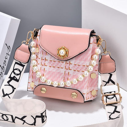 Pink handbag with pearl details and a strap on a white background