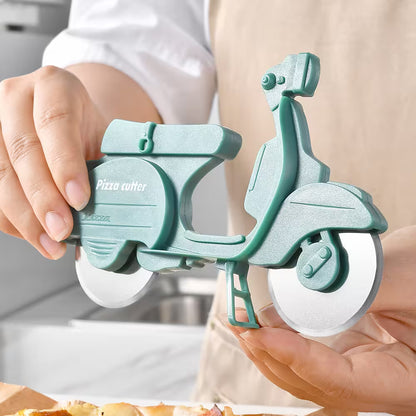 Scooter-shaped pizza cutter held by a person with a blurred kitchen background