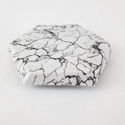Hexagonal stone with black and white marbled pattern on a light gray background