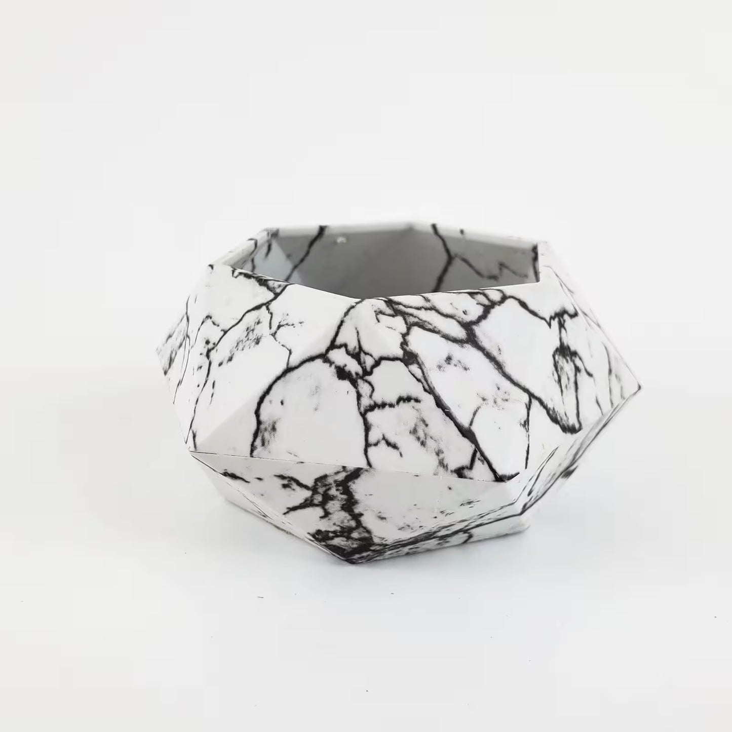 Geometric black and white patterned container on a white background