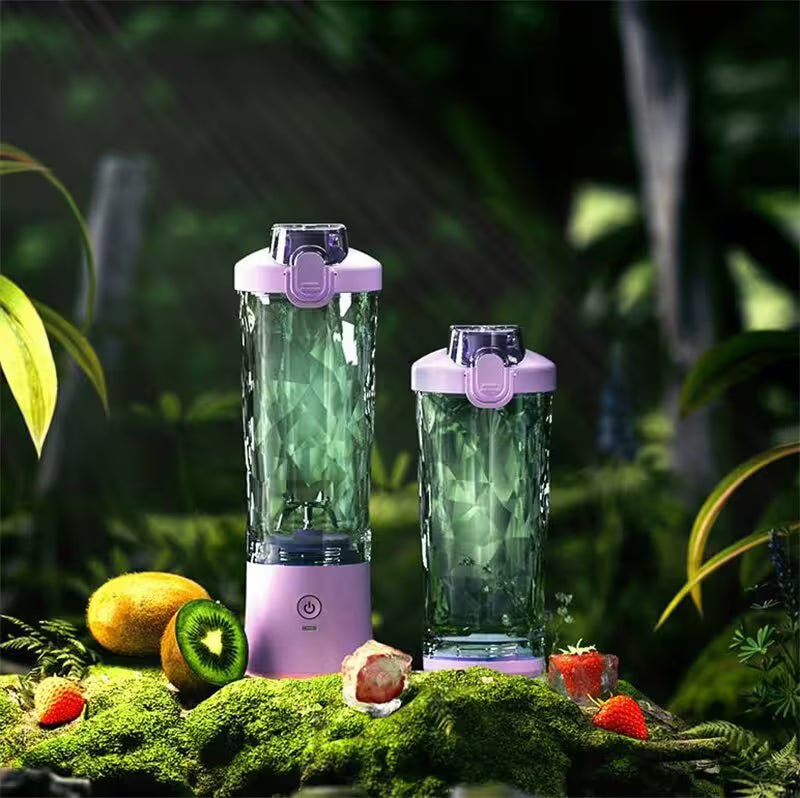 Two portable blenders with green liquid on a natural background with fruits.