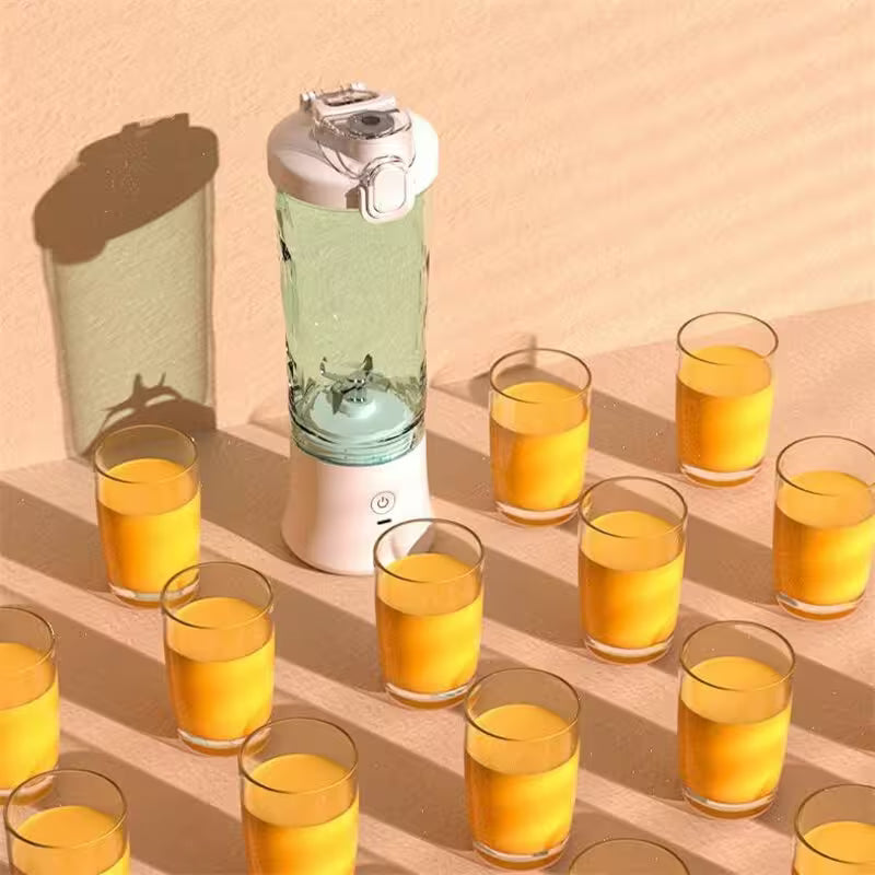 Blender with orange juice in glasses on a beige surface