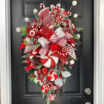 Decorative Christmas wreath with red, white, and green colors on a black door.