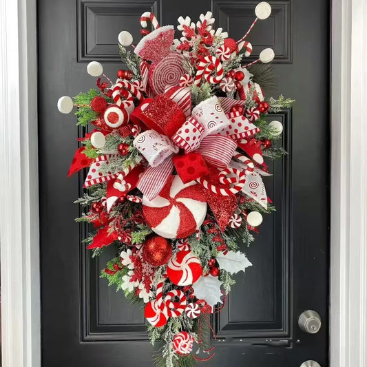 Decorative Christmas wreath with red, white, and green colors on a black door.