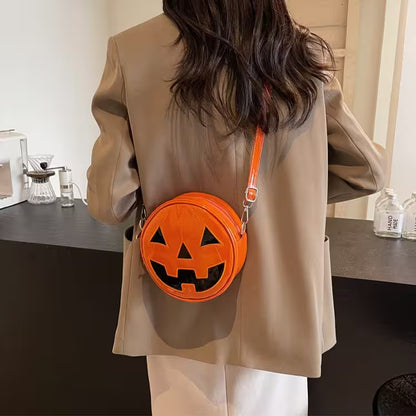 Person wearing a beige coat with an orange pumpkin-shaped bag.