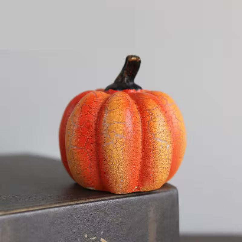 Small orange pumpkin with a cracked texture on a gray surface