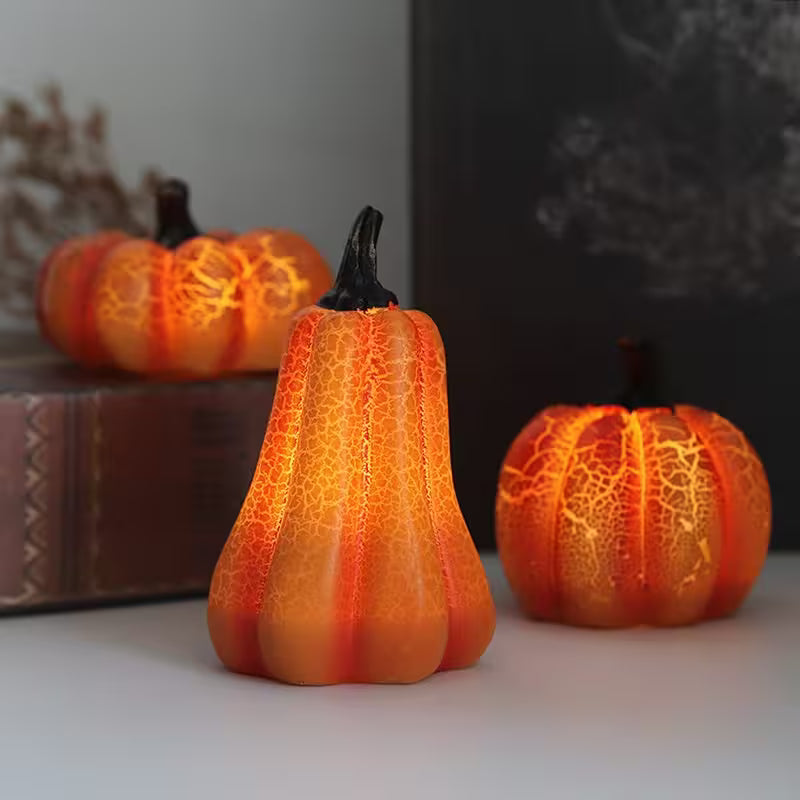 Three decorative pumpkins with textured surface on a neutral background