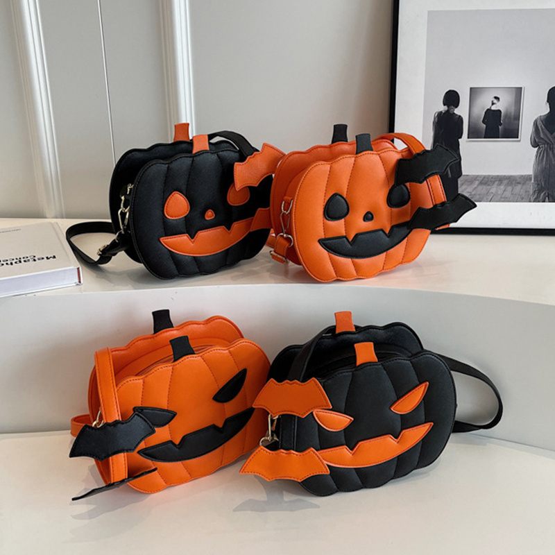 Four Halloween-themed bags shaped like jack-o'-lanterns on a white surface.