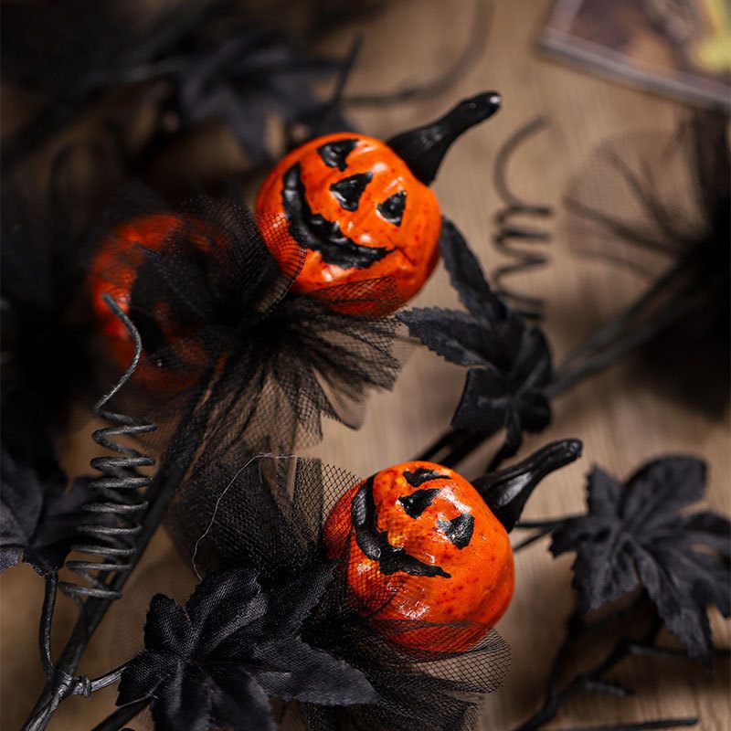 Halloween-themed decorations with jack-o'-lanterns and black ribbons on a wooden surface.