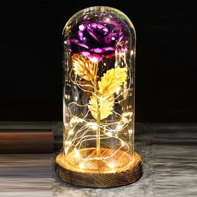 Decorative glass dome with glowing flowers on a wooden base against a dark background