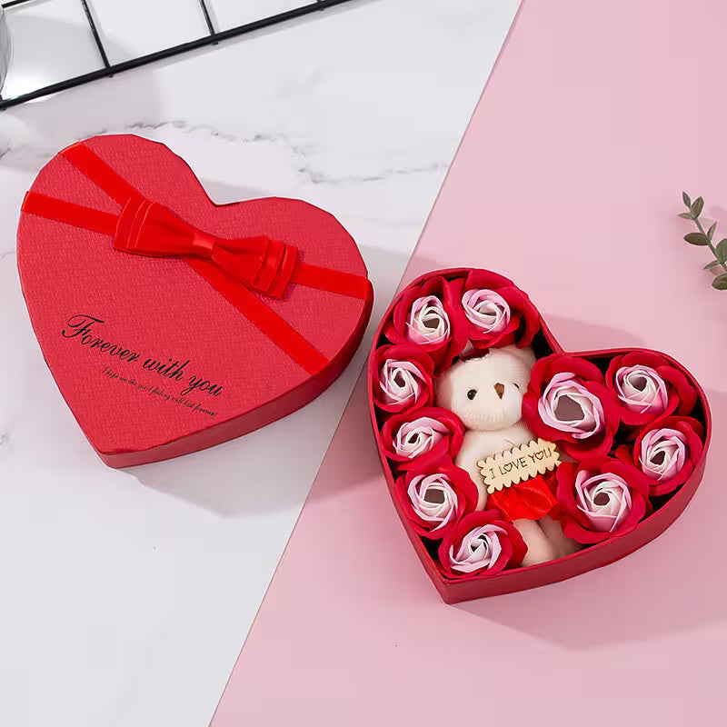 Heart-shaped gift box with a teddy bear and roses on a pink surface