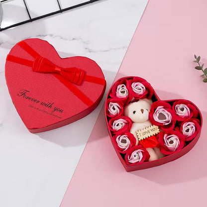 Heart-shaped gift box with a teddy bear and roses on a pink surface