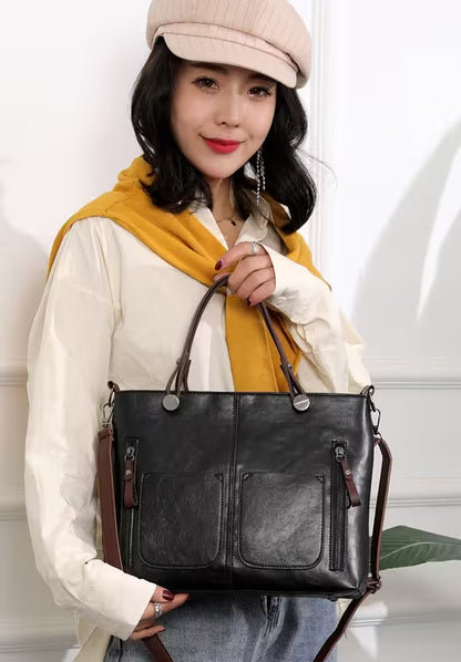Woman holding a black leather handbag with a white wall background
