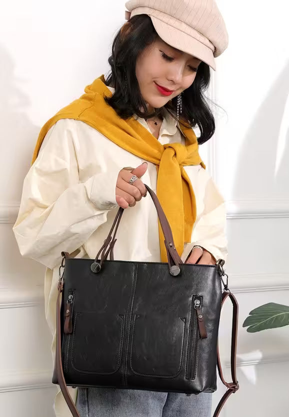 Woman holding a black leather handbag against a white background