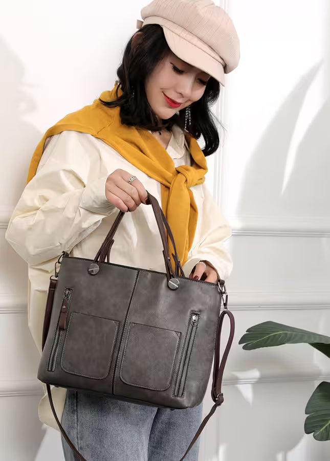 Woman holding a gray handbag with a white background