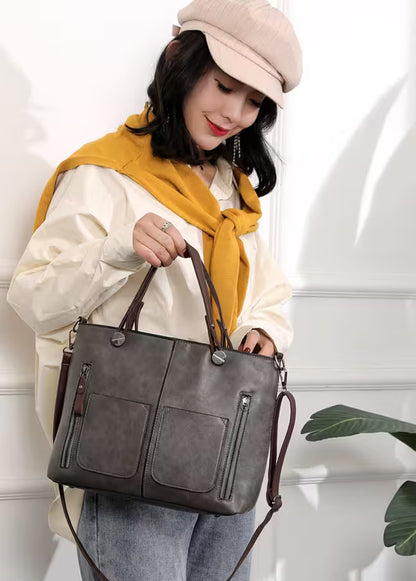 Woman holding a gray handbag with a white background