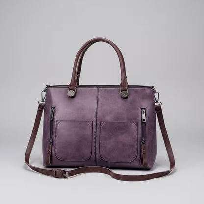 Purple handbag with a shoulder strap on a light gray background