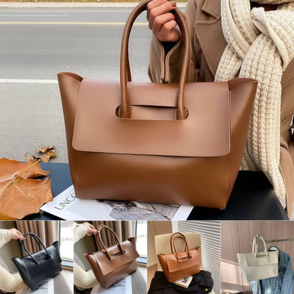 Brown handbag held by a person with a blurred street background