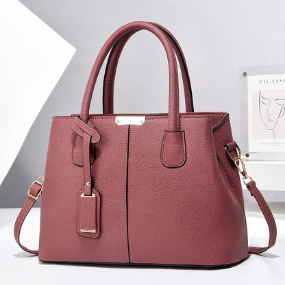 Pink handbag with gold accents on a white background