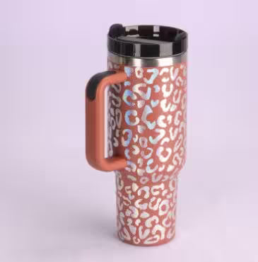 Travel mug with a colorful leopard print pattern on a light purple background