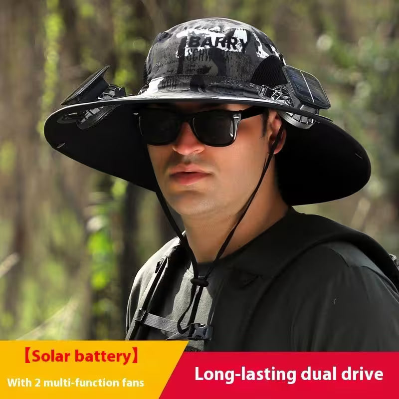Person wearing a large black hat with 'BARRY' branding, sunglasses, and a solar battery pack in a forest setting.