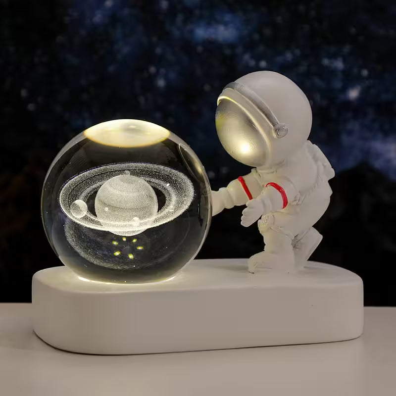 Spaceman figurine interacting with a transparent sphere containing a Saturn model on a dark background