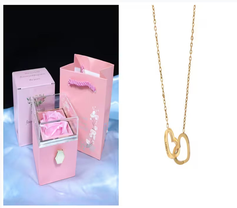 Pink jewelry box with pink satin bag and gold necklace on a white background