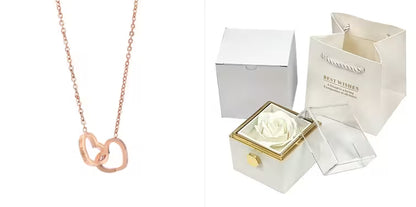 Rose gold necklace next to a white box with a preserved rose and a card inside.