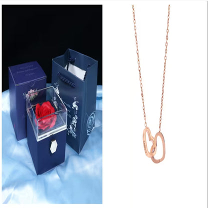 Rose in a box with a blue box and a rose gold necklace on a white background