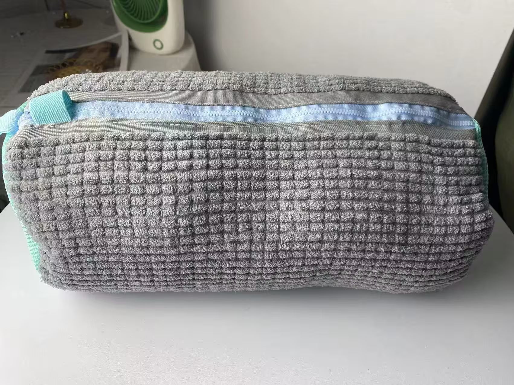 Gray textured pouch on a white surface