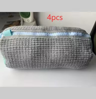 Gray textured pouch with a white interior, containing blue items, on a light gray background.