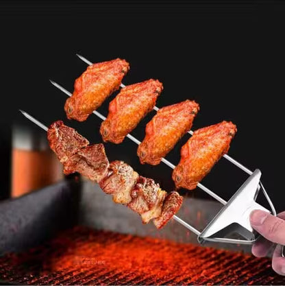 Skewer with grilled chicken wings held over a grill