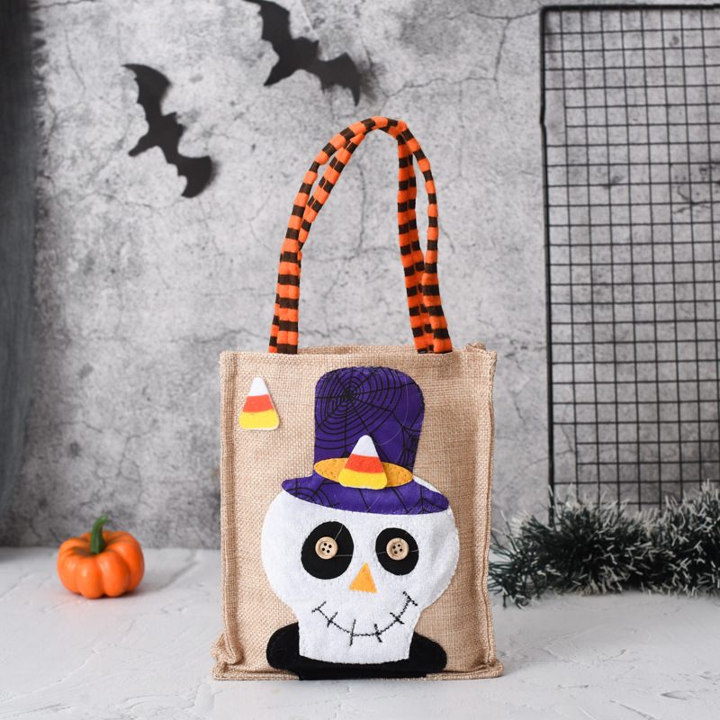 Halloween-themed tote bag with a skull design and candy corn decorations on a gray background.