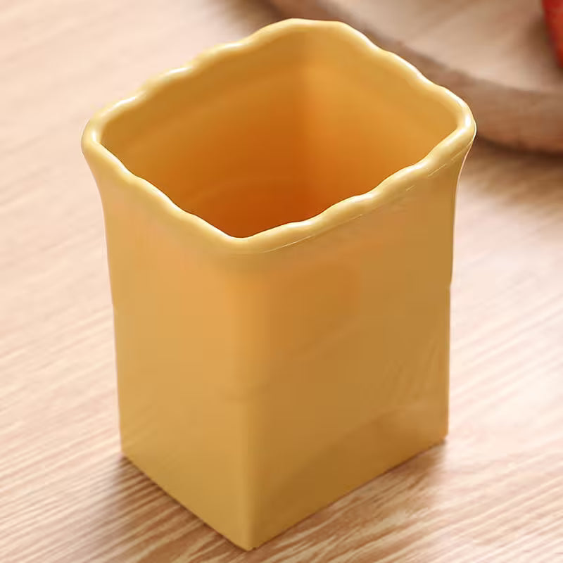 Yellow ceramic cup on a wooden surface