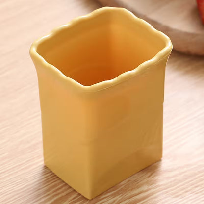 Yellow ceramic cup on a wooden surface