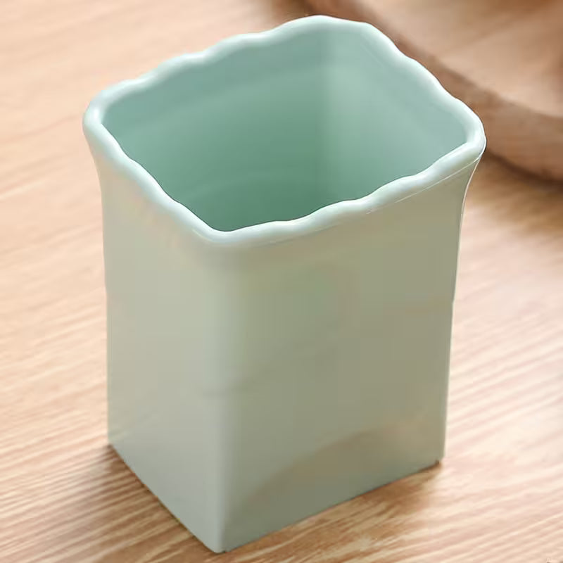 Light green ceramic square cup on a wooden surface