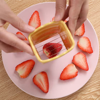 Strawberries being cut with a small square knife on a pink plate.