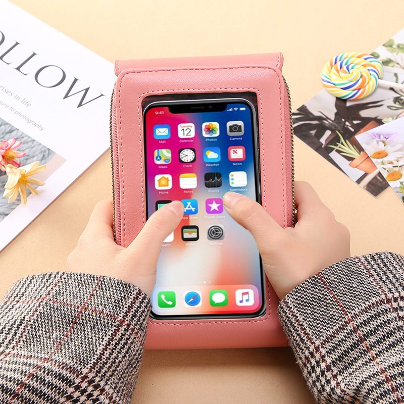 Person holding a pink phone case with a smartphone inside, on a light surface with magazines.