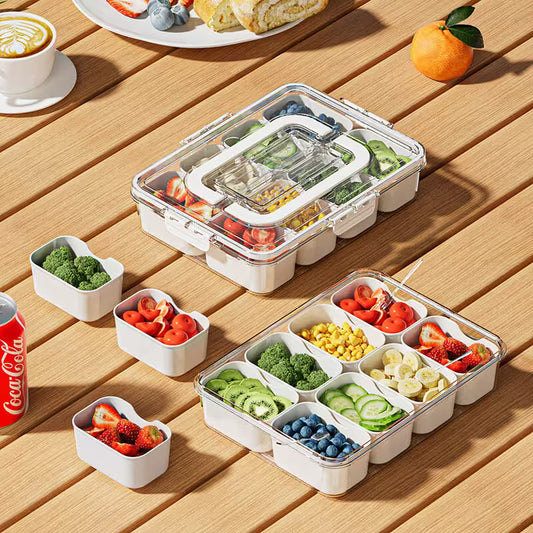 Meal prep containers with compartments filled with fruits and vegetables on a wooden table.