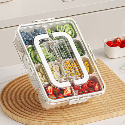 Transparent bento box with compartments filled with various fruits and vegetables on a wooden cutting board.