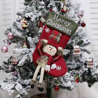 Red Christmas stocking with a snowman design hanging on a decorated tree.
