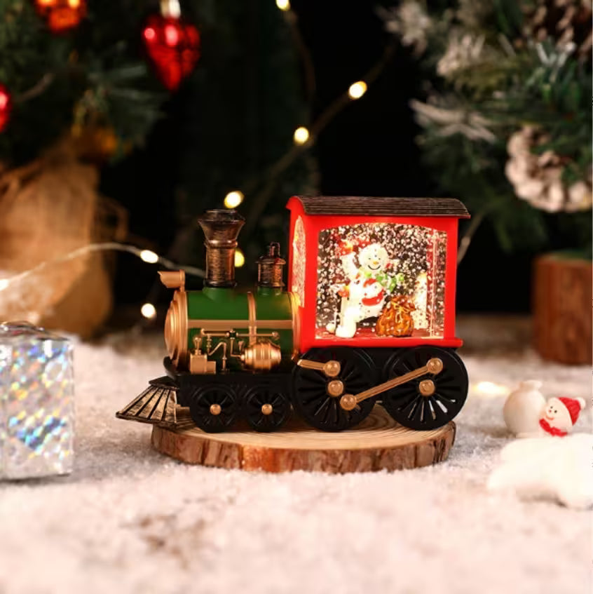 Decorative train with a snow globe on a wooden base in a festive setting.