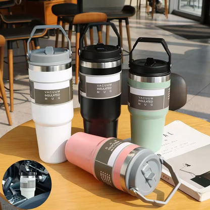 Four vacuum insulated mugs on a table with a blurred indoor background