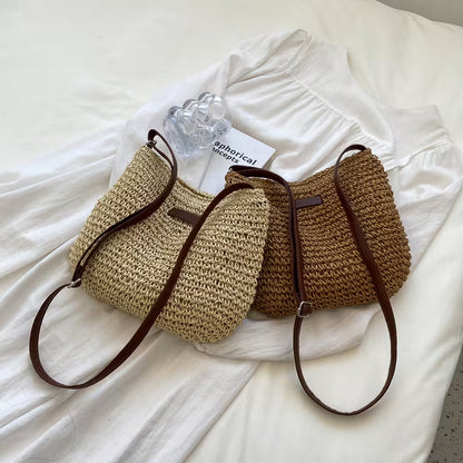 Two woven handbags with brown straps on a white fabric background