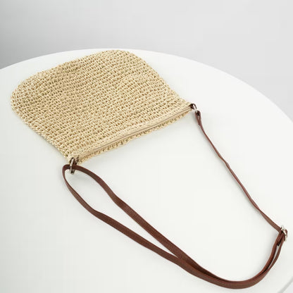Beige woven handbag with a brown strap on a white background