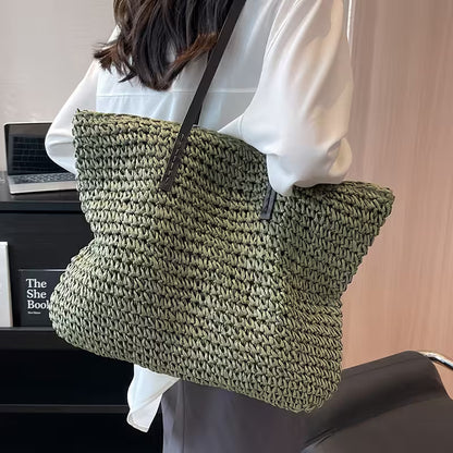 Person holding a green woven handbag in an indoor setting
