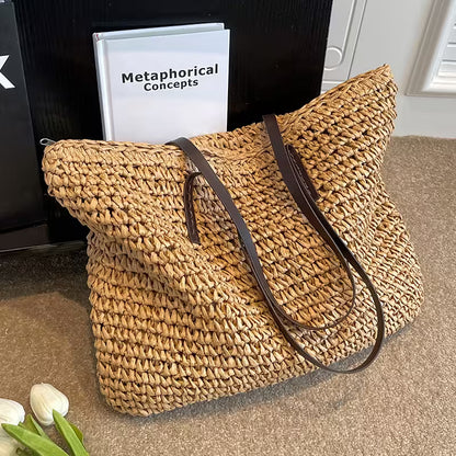 Woven straw bag with brown leather straps on a carpeted floor.